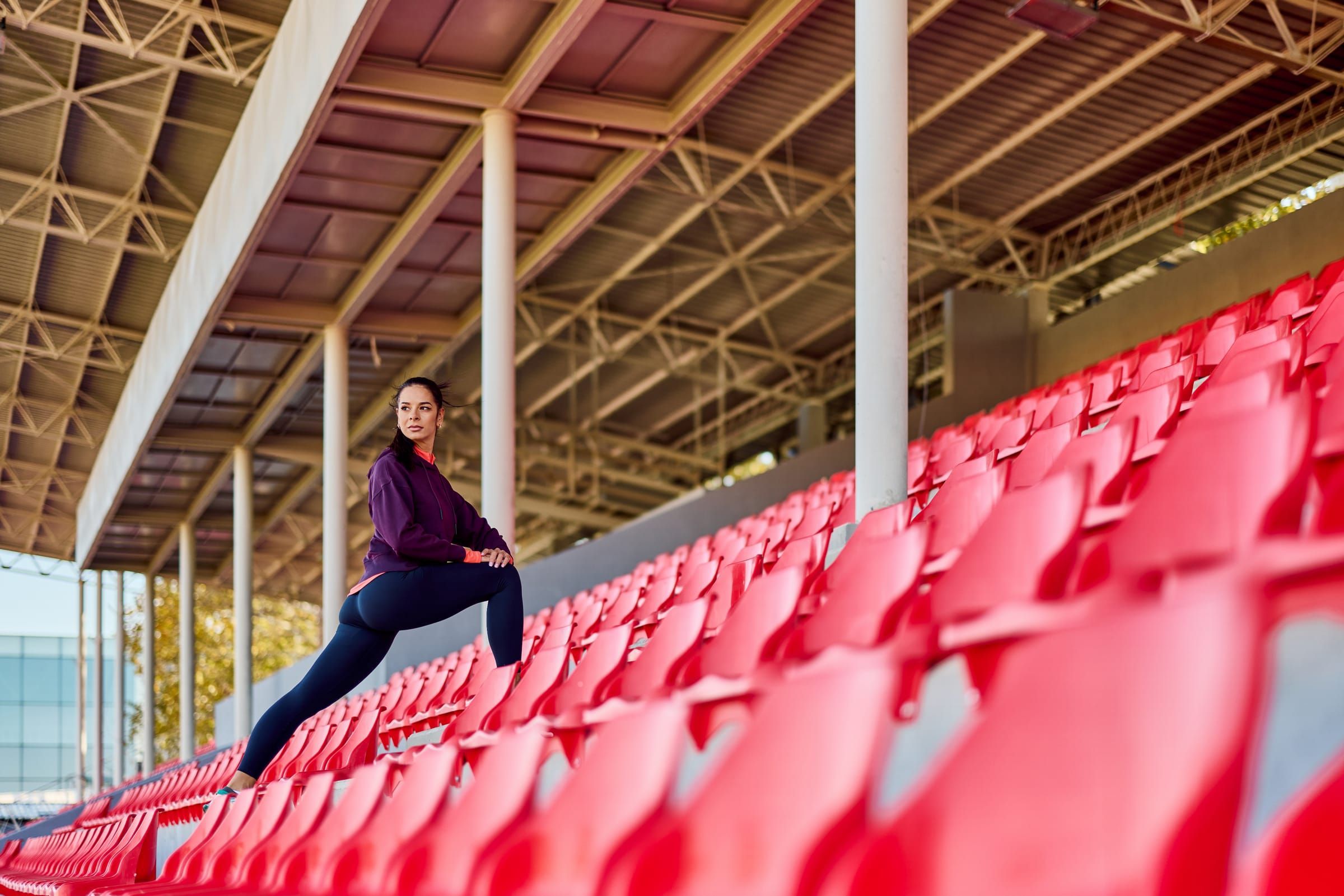 Person stretching among red stadium seats
