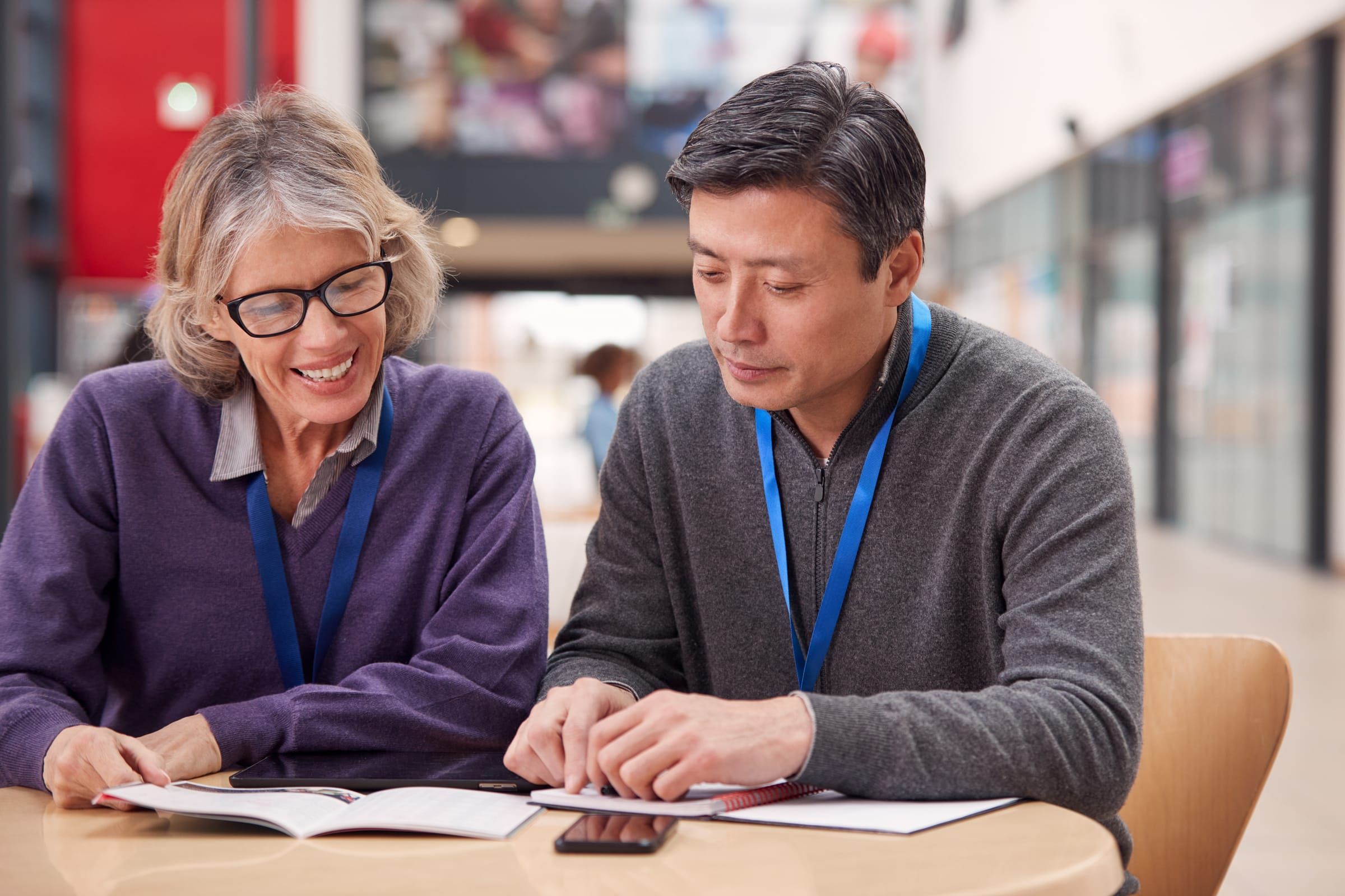 Two recreation center staff members reviewing paperwork together at a table