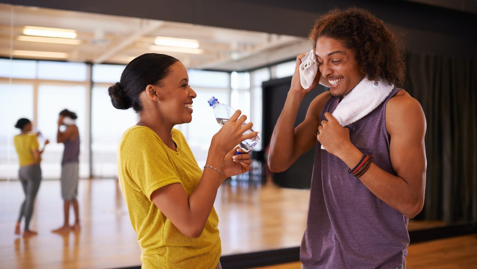 Two people laughing together in a community center dance studio
